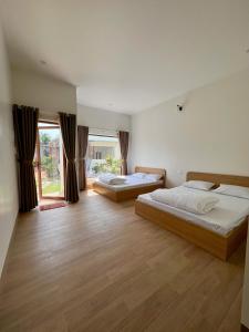 sypialnia z dwoma łóżkami i dużym oknem w obiekcie Vy's Home Homestay Mũi Né w mieście Mui Ne