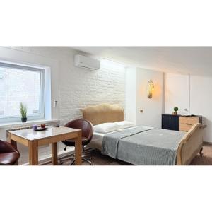 Un dormitorio con una cama, una mesa y una silla. en Sumska Apartment Lux, en Járkov