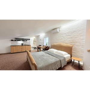 Un dormitorio con una cama y una mesa y una cocina. en Sumska Apartment Lux, en Járkov