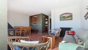 ein Wohnzimmer mit Sofa, Stühlen und einem Tisch in der Unterkunft Guils Cal Peiró in Guils de Cerdaña