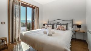 ein Schlafzimmer mit einem großen weißen Bett mit einem großen Fenster in der Unterkunft Guils Cal Peiró in Guils de Cerdaña