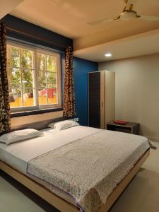 a bedroom with a large bed and a window at Guesthouse Sakina Colva in Colva