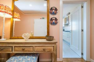 een badkamer met een houten dressoir en een spiegel bij Saboia -Spacious Gorgeous Apartment in Monte Estoril