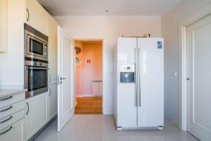 een keuken met een witte koelkast in de kamer bij Saboia -Spacious Gorgeous Apartment in Monte Estoril +56 foto's