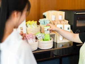 a woman standing in front of a counter in a store at Hotel Resol Ueno in Tokyo
