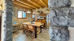 ein Esszimmer mit einem Tisch und einer Steinwand in der Unterkunft Masía Cal Kenyon in Bor
