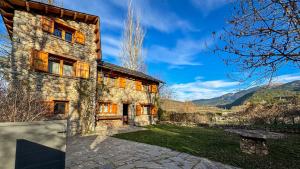ein altes Steinhaus mit einer Steinauffahrt in der Unterkunft Masía Cal Kenyon in Bor