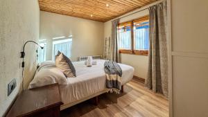 ein Schlafzimmer mit einem Bett und einem großen Fenster in der Unterkunft Masía Cal Kenyon in Bor