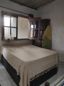 una camera da letto con un letto con una tavola da surf sul muro di Raízes kit net a Itacaré