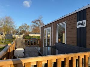 a deck with a house with a couch on it at Chalet Meerhuus Lauwersoog in Lauwersoog