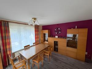 een keuken met een tafel en stoelen en paarse muren bij Ferienwohnung Ruhrtal in Bestwig