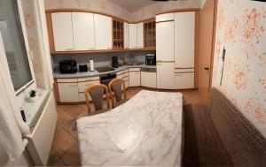 een keuken met witte kasten en een tafel en stoelen bij Ferienwohnung Ruhrtal in Bestwig +3 foto's