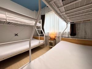a bedroom with two bunk beds and a lamp at グランディオーソ沖縄ヴィラ恩納5 in Onna