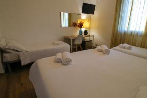 una camera d'albergo con due letti con asciugamani sopra di Hotel Al Posta a Casarsa della Delizia