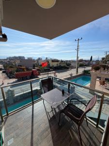 a balcony with a table and chairs and a pool at Birds inn in Kuşadası