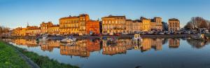 una città con edifici e barche in acqua di Appartement Prestige Citadelle Blaye - Lumineux & Spacieux - 2 chambres a Blaye