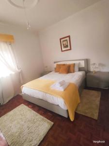 a bedroom with a large bed with a yellow blanket at Vergikosk House - villa 4 quartos com piscina privada in Bombarral