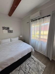 a bedroom with a white bed and a window at The Vantage in Lusaka +13 photos