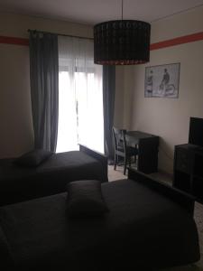 1 Schlafzimmer mit 2 Betten, einem Fenster und einem Schreibtisch in der Unterkunft B&B Napoli Napoli in Neapel + 12 Fotos