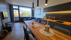 a living room with a wooden table and a kitchen at Dachstein104 in Bad Goisern