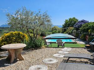 a patio with a table and a bench and an umbrella at gite ventoux in Puyméras