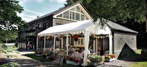 eine Gruppe von Menschen, die vor einem Gebäude an einem Tisch sitzen in der Unterkunft Relaxing 1 bed apartment on Tetbury High St in Tetbury + 6 Fotos