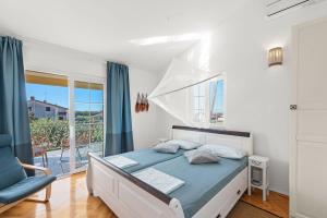 RošiniHoliday House with Private Pool Villa Seabird的一间卧室，里面有一张床、一把椅子和一扇窗户