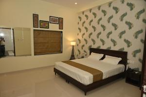 SHAURYAAKSH HOTEL & Home stay في جايبور: غرفة نوم مع سرير بجدار نمط سمك