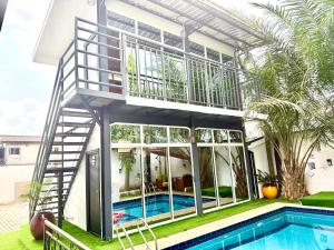 a house with a balcony and a swimming pool at TGH Gracies Hotel in Port Harcourt