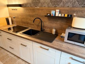 a kitchen with a sink and a microwave at Appartement Sissi in Altmünster +42 photos