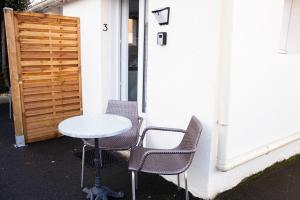 a table and four chairs next to a building at Charmant Studio avec parking Résidence Zénith in Caen