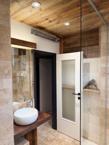 a bathroom with a sink and a glass door at Appartement Sissi in Altmünster
