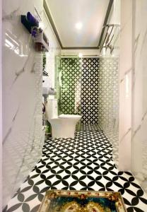a bathroom with a toilet and a black and white tile floor at Hoàng Nga 1 Apartment in Phan Thiet +95 photos