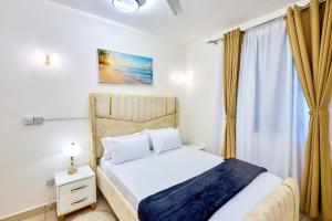 a bedroom with a white bed and a window at Diani beachview escape in Ukunda +44 photos