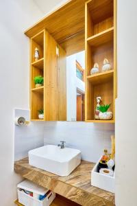 a bathroom with a white sink and wooden cabinets at Diani beachview escape in Ukunda