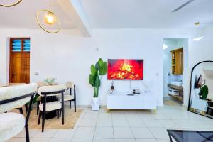 a living room with a table and a tv on a wall at Diani beachview escape in Ukunda