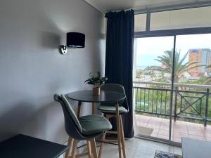 a room with a table and chairs and a balcony at Brookes Hill Suites Bay Watch in Gqeberha