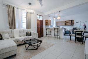 a living room and kitchen with a couch and a table at Diani beachview escape in Ukunda