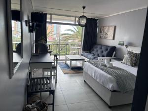 ein Wohnzimmer mit einem Bett und einer Couch in der Unterkunft Brookes Hill Suites Bay Watch in Summerstrand