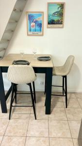 un tavolo da pranzo con due sedie e un tavolo con bicchieri da vino di Quiet cozy apartment, air conditioning, swimming pool a Vidauban Altre 13 foto