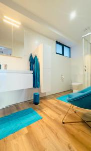 un bagno con tappetini blu su un pavimento in legno di Sea Front a Câmara de Lobos