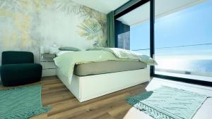 una camera da letto con un letto e una grande finestra di Sea Front a Câmara de Lobos