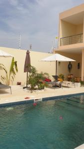 una piscina con ombrelloni e un edificio di Les Studios de l'Oasis a Ngaparou