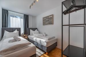 a bedroom with two beds and a mirror at Stadtapartments Luna by Cosy Homes in Villach