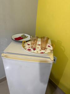 two glasses sitting on top of a white refrigerator at Quarto privado próximo ao centro 10 in Manaus