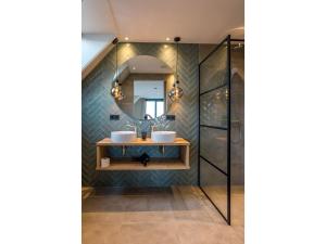 a bathroom with two sinks and a mirror at Modern villa in De Cocksdorp near the beach in De Cocksdorp