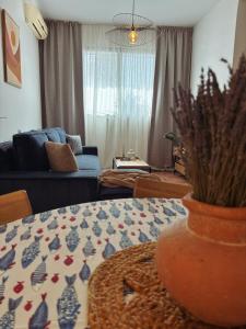 a living room with a table and a couch at Flora Apartment - near the sea in Bar, Susanj