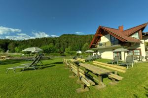 a group of wooden benches in front of a building at Seehaus Rausch in Egg am Faaker See