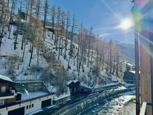 采尔马特Peaky Riders Self Check-in Hotel的享有雪覆盖的山峰和火车的景色 更多13张照片