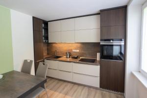 a kitchen with white cabinets and a table at HARMONY Apartment in Janske Lazne